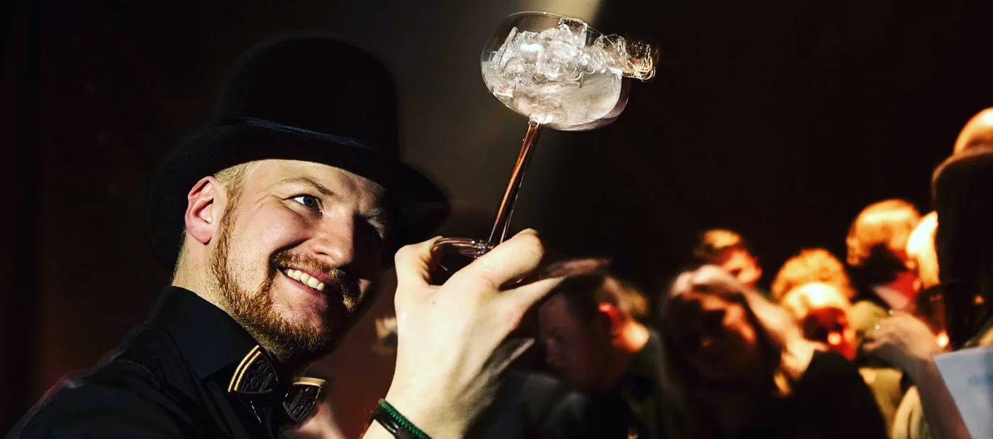 Nico ojentaa savuavaa drinkkiä yleisölle