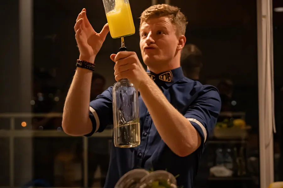 Nico kaataa juomaa pullosta baaritiskillä