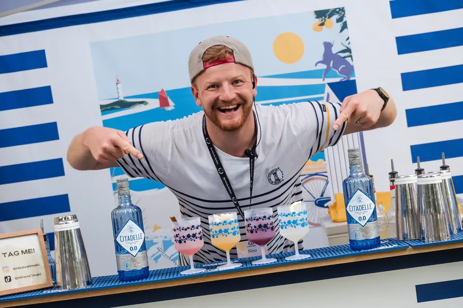 Nico Välimäki brändätyn juomapisteen takana messuilla